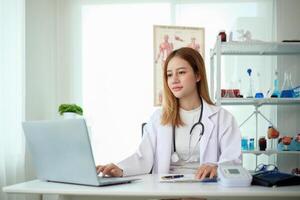 Female doctor working at office desk at in health clinic or hospital photo