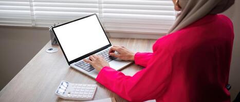 Muslim businesswoman while working with laptop, Empty screen of laptop, Business and financial concept photo