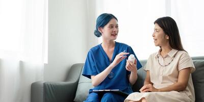 Caregiver woman hold medicine pill bottle, explain prescription to elderly old woman in living room in house photo