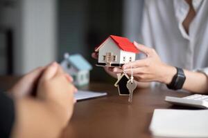 Real estate agent hand over property or new home keys to a customer photo