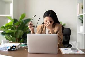 Eco friendly, businesswoman young asian stress in working on laptop while sitting at home office photo