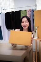 Happy young asian woman startup small business freelance holding parcel box. Online marketing packing box delivery concept photo