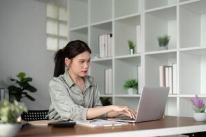 mujer de negocios utilizando ordenador portátil computadora trabajo desde hogar en habitación. Lanza libre, verde habitación área, estilo de vida concepto foto