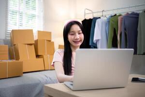 Young woman working online ecommerce shopping at her shop. Young woman sell prepare parcel box of product for deliver to customer. Online selling, ecommerce. Selling products online photo