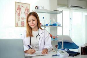 Female doctor working at office desk at in health clinic or hospital photo