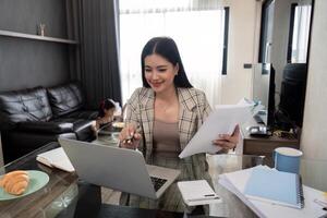 Business woman or mom working with her little daughter at a laptop. Freelance, work from home photo