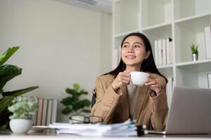 Work from home. Businesswoman using laptop computer in room. Eco friendly businesswoman working on desk with drink coffee in the morning, freelance photo