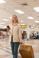 un mujer asiático caminando en un aeropuerto. móvil, maleta y viaje con un joven hembra en un internacional viaje para trabajo o viaje foto