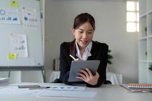 Businesswoman in office using tablet computer, audit documents and financial analysis, business people concept photo