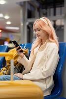 Happy asian tourist woman using mobile smartphone with suitcase traveling between waits for flight in Airport Terminal, flight check in, Tourist journey trip concept photo