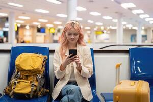 Happy asian tourist woman using mobile smartphone with suitcase traveling between waits for flight in Airport Terminal, flight check in, Tourist journey trip concept photo