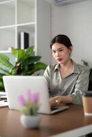 mujer de negocios utilizando ordenador portátil computadora trabajo desde hogar en habitación. Lanza libre, verde habitación área, estilo de vida concepto foto