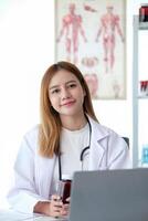 Female doctor working at office desk at in health clinic or hospital photo