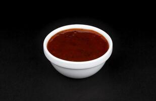 Grill sauce in bowl isolated on black background photo