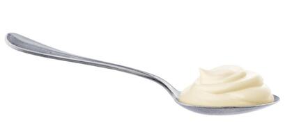 Sour cream in spoon isolated on white background photo