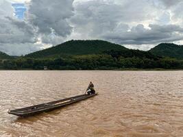 Boat in the River with a Random Boatman  in MekongRiver near Luang Prabang in Landscape on 23 July, 2022 photo