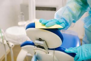 un enfermero desinfecta trabajo superficies en el del dentista oficina. foto