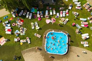 parte superior ver de un al aire libre sitio para personas a relajarse dónde allí es un nadando piscina y un lote de Dom camas foto