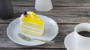 limón pastel en un plato con un taza de café foto