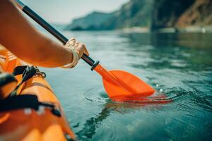 Kayak paddle sea vacation. Person paddles with orange paddle oar on kayak in sea. Leisure active lifestyle recreation activity rest tourism travel photo