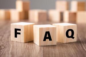 Frequently asked question concept. Wooden blocks with word FAQ on wooden background. photo