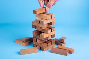 Hand of man piling up and stacking a wooden block. Plan and strategy in business, Risk To Make Business Growth Concept photo