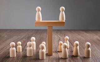 Wooden people figures on top of wooden blocks. Career growth, development and leadership photo