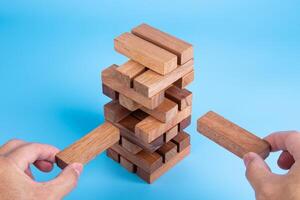 Hand of man piling up and stacking a wooden block. Plan and strategy in business, Risk To Make Business Growth Concept photo