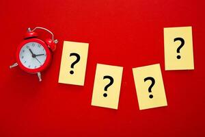 a question mark and a red alarm clock . FAQ frequency asked questions. photo