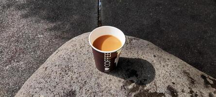 ai generado taza de café en un grande rock foto