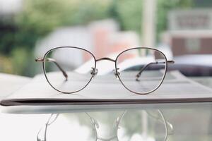 Eyeglasses on table, progressive lenses, eyeglasses for the elderly, glasses progressive lens, eyeglass progressive lens, close-up of glasses on lenses test, looking through glasses photo