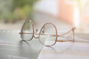 los anteojos en mesa, progresivo lentes, los anteojos para el anciano, lentes progresivo lente, lente progresivo lente, de cerca de lentes en lentes prueba, mirando mediante lentes foto