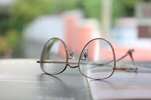 los anteojos en mesa, progresivo lentes, los anteojos para el anciano, lentes progresivo lente, lente progresivo lente, de cerca de lentes en lentes prueba, mirando mediante lentes foto