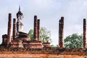 antiguo sentado Buda imagen a wat maha ese en sukhothai histórico parque, tailandia foto