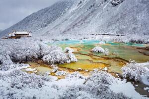 View of icy Colored Lake and Tibetan Temple in Huanglong, Sichuan, China photo