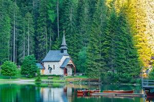 Mañana ver de pequeño antiguo Iglesia a el banco de lago braies en sur Tirol, Italia foto
