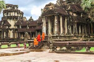 budista monjes caminando a angkor wat en siem recoger, Camboya. foto