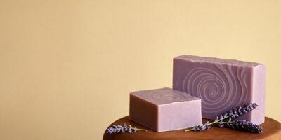 Natural handmade soap bars and lavender flowers on beige background. Copy space for text on the left of the image. photo