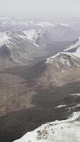 large snow patch left over on the volcanic rock field of a mountain in summer video