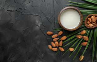 AI generated Almond milk in glass and almond nuts with palm leaf on black stone background photo