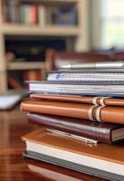 AI generated Stack of books. A stack of spiral notebooks and hardcover books with a pen on top photo