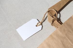 Part of a cardboard kraft package with a white tag on a rope with handles for delivery or gift photo