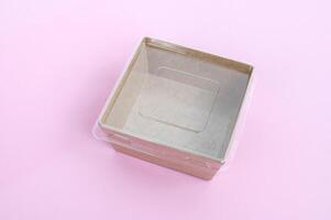 Transparent plastic and cardboard food container on a pink background. photo