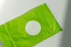 Round white sticker on green poly mailer envelope. photo