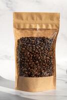 A kraft paper bag with coffee beans for viewing with a highlighted shadow lies on a white background photo