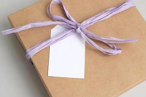 Mockup of a tag on a brown craft box with a ribbon. Space for text, copy space photo