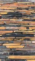 Vertical Wall constructed with stacked stone slabs, abstract background photo