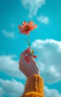 AI generated A hand lifts a single flower towards a vibrant blue sky dotted with clouds photo