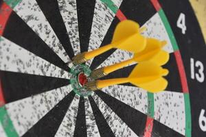 Dartboard with Three Darts in the Center of the Board photo