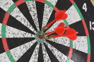 Dartboard with Red Darts Near the Bullseye photo